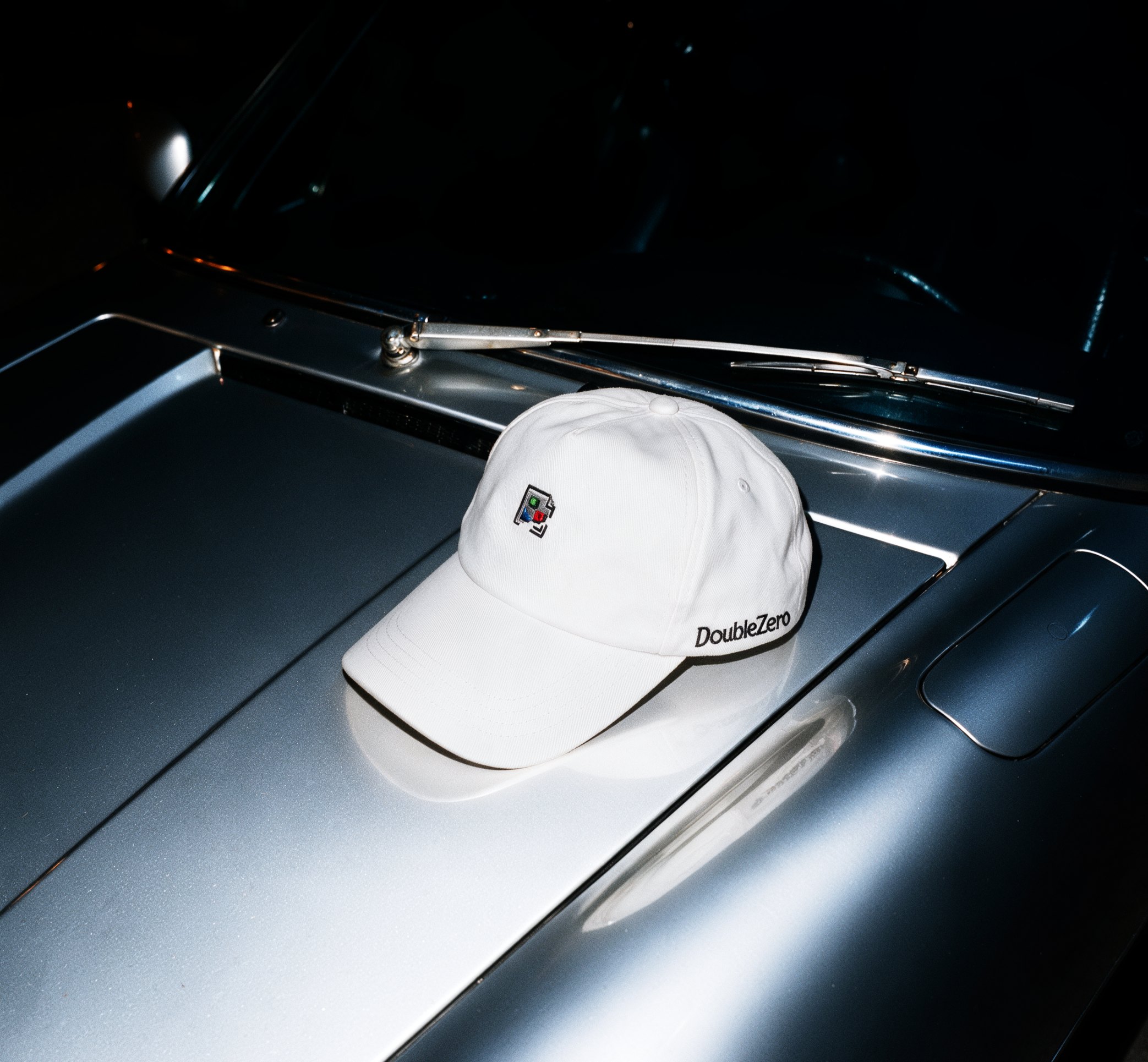 White cap resting on a reflective car body