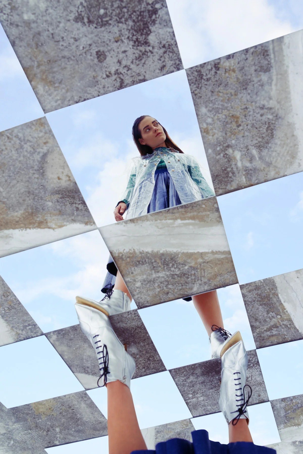 Fragmented figure reflected in a grid of mirrors