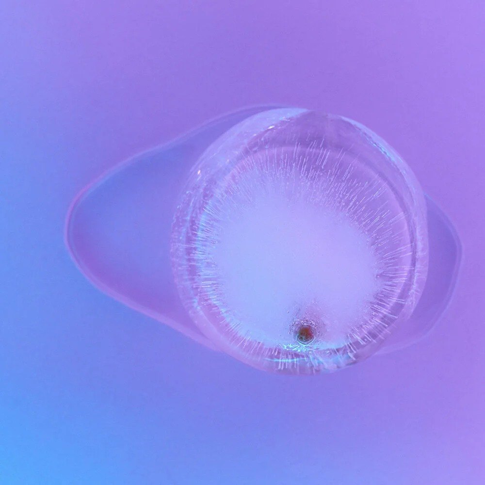 Pale translucent circular form on a violet background