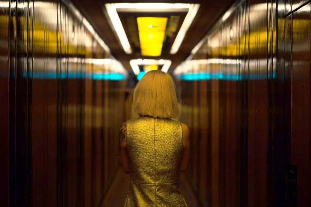 Figure moving through a yellow-lit corridor