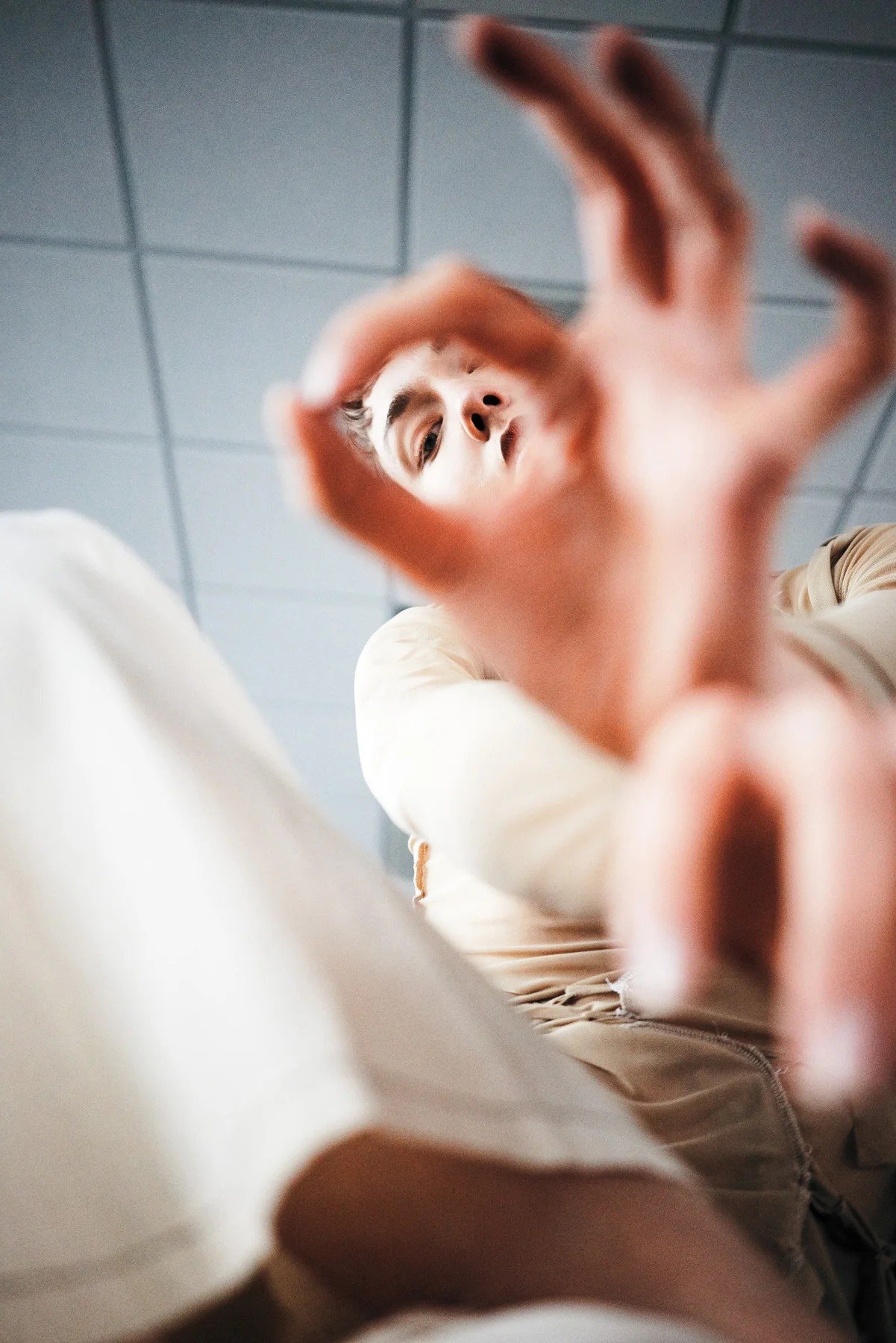 Close-up portrait framed by a raised hand